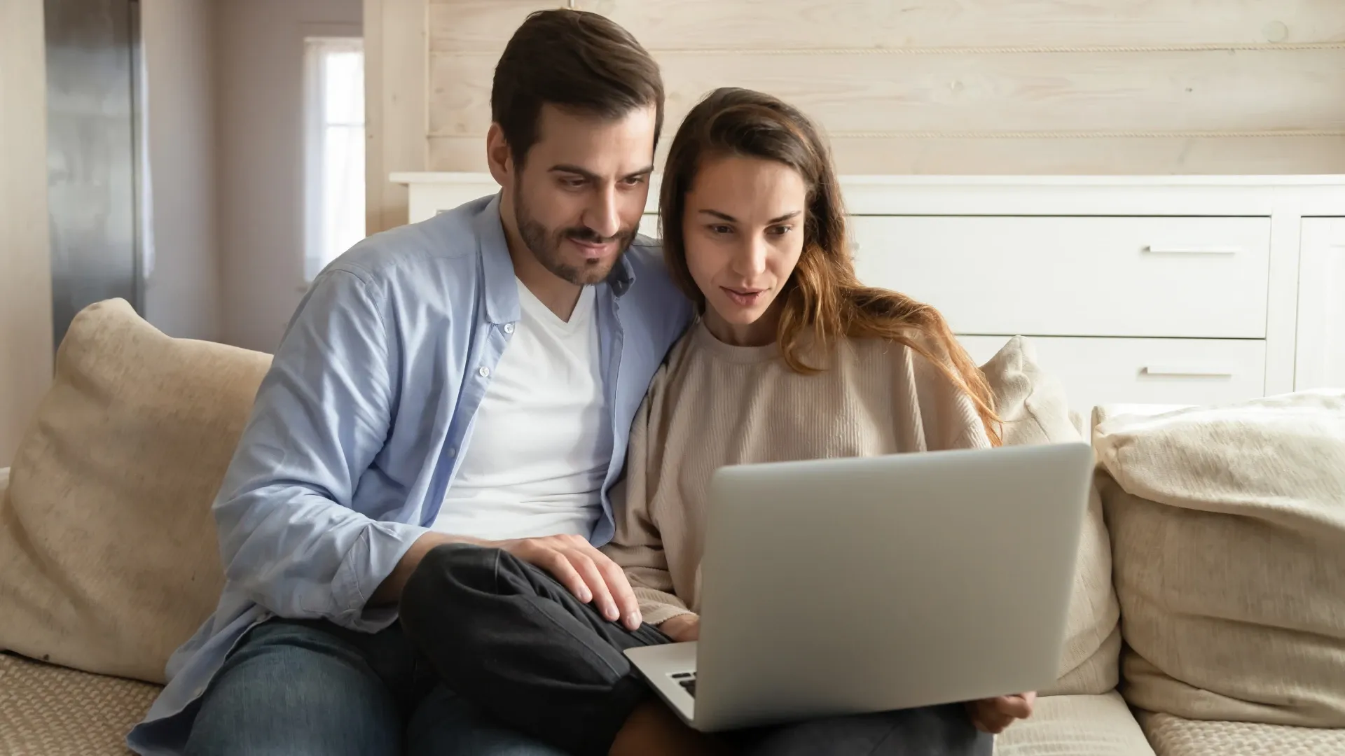 Couple captivated by the digital experience they are viewing on a laptop